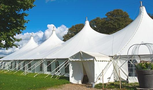 tall green portable restrooms assembled at a music festival, contributing to an organized and sanitary environment for guests in Norwood