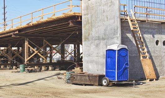 a lineup of sanitized portable restrooms on a busy construction site